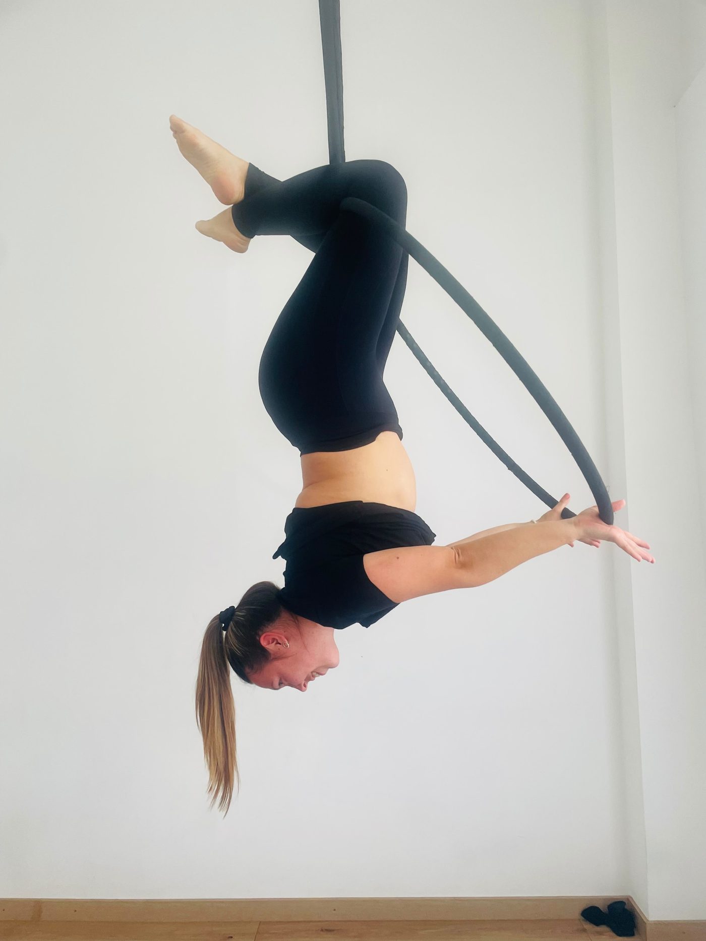 Alumna invertida sobre el aro aéreo
